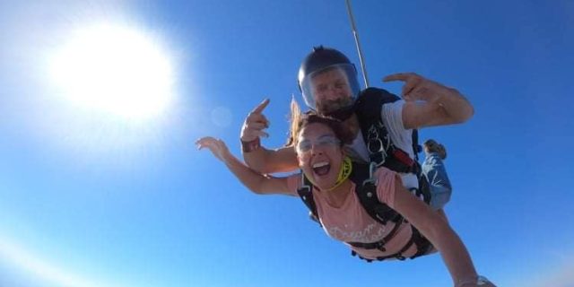 Stoked female tandem passenger and instructor freefalling over Costa Rica